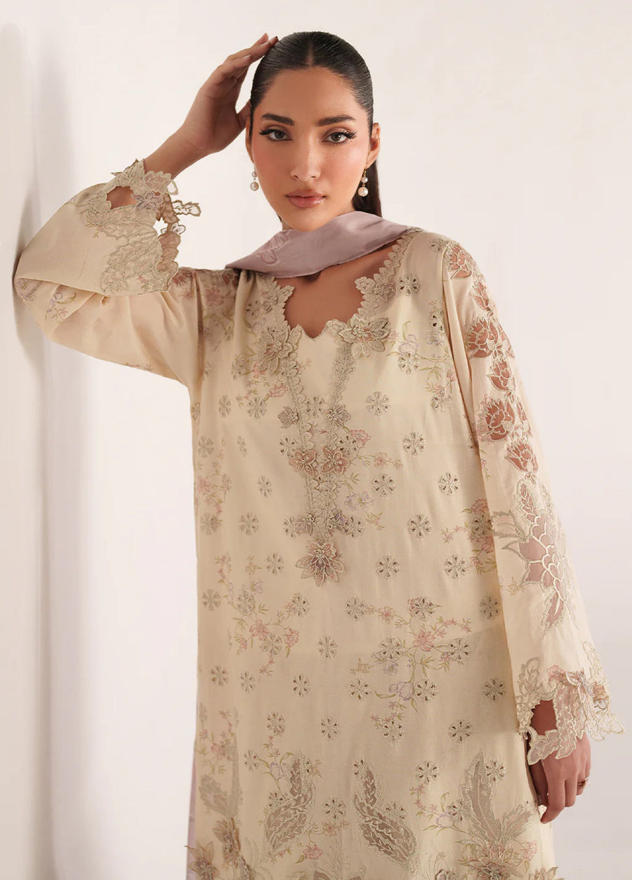 Close-up of the embroidered neckline and patterned sleeves in cream fabric with intricate floral lace embellishments