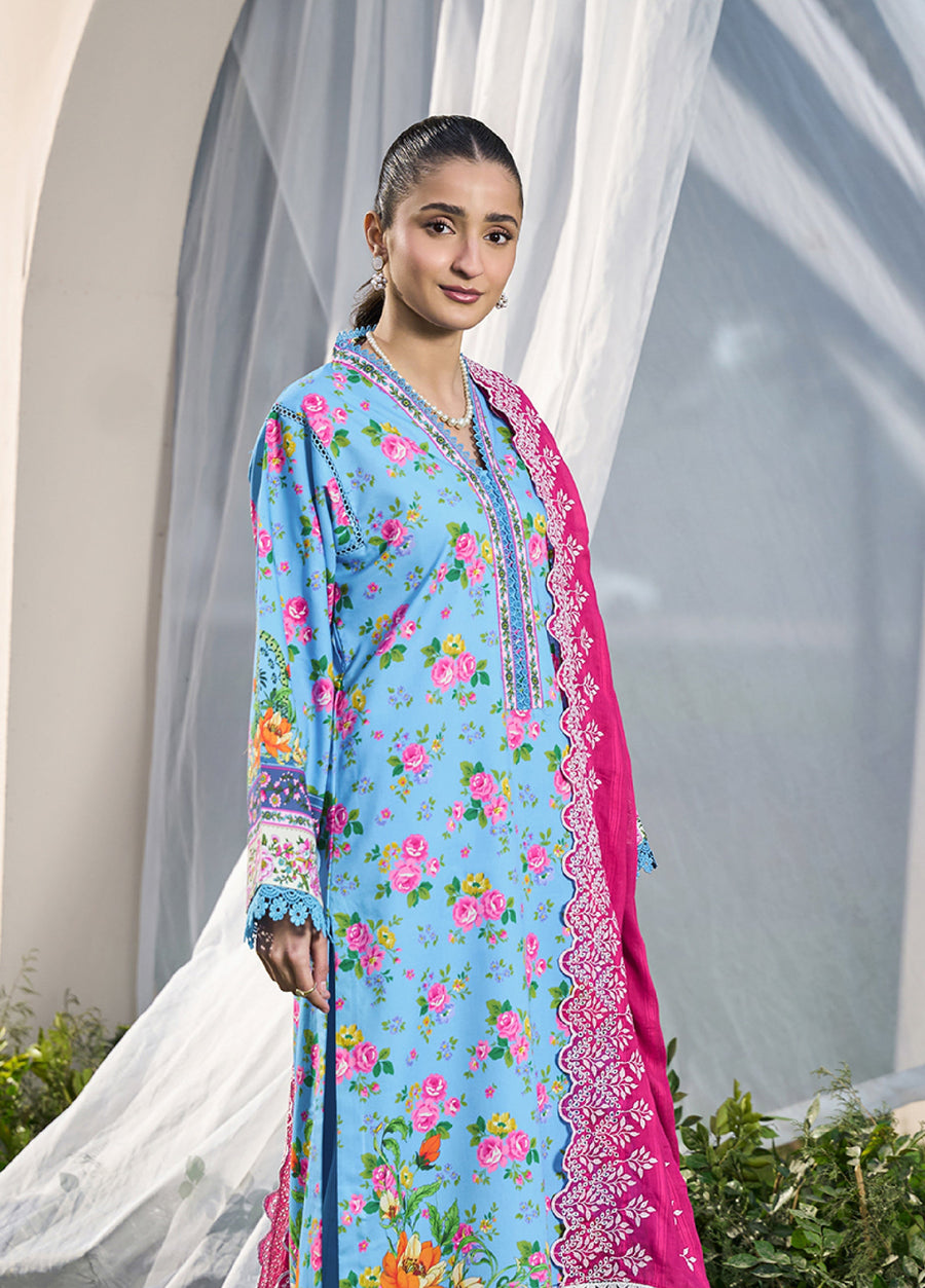 Close-up of woman wearing sky-blue floral printed lawn shirt with detailed embroidery and bright fuchsia dupatta featuring white chikankari embroidery edging
