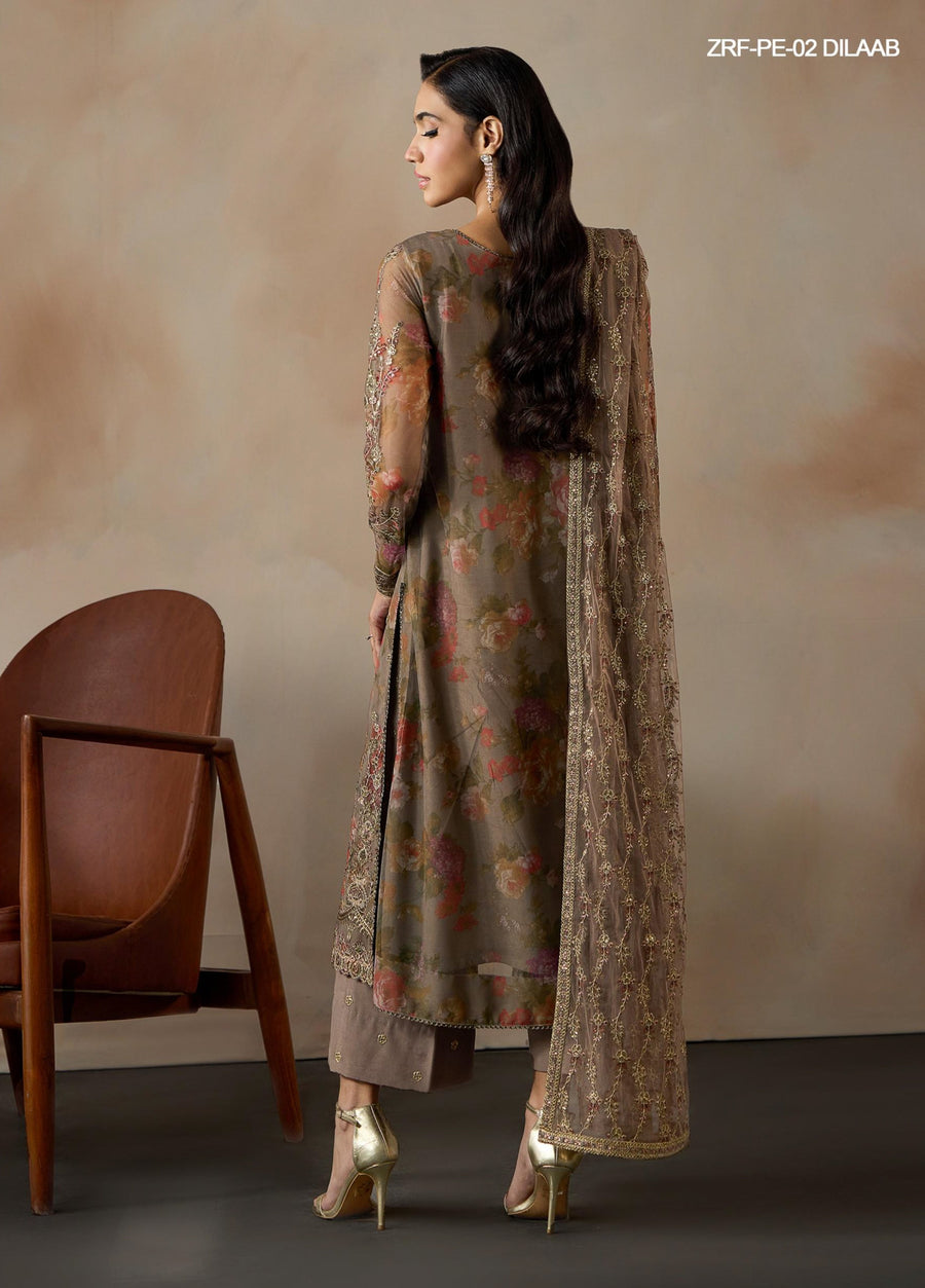 Back view of woman in embroidered floral net shirt and embroidered raw silk trousers holding matching dupatta