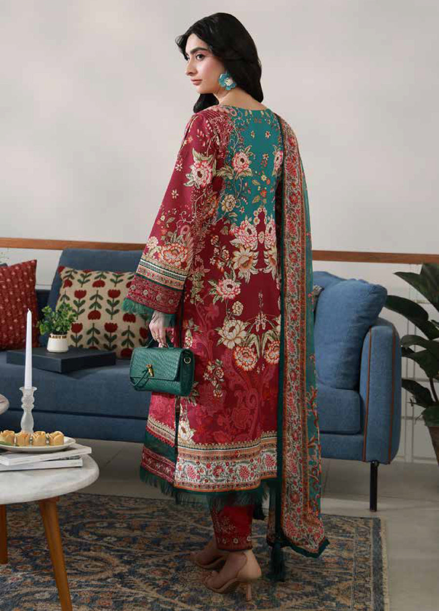 Rear view of woman in embroidered floral lawn suit showing contrasting red and green floral print on the back along with a printed chiffon dupatta and nude heeled sandals in a cozy living room setting
