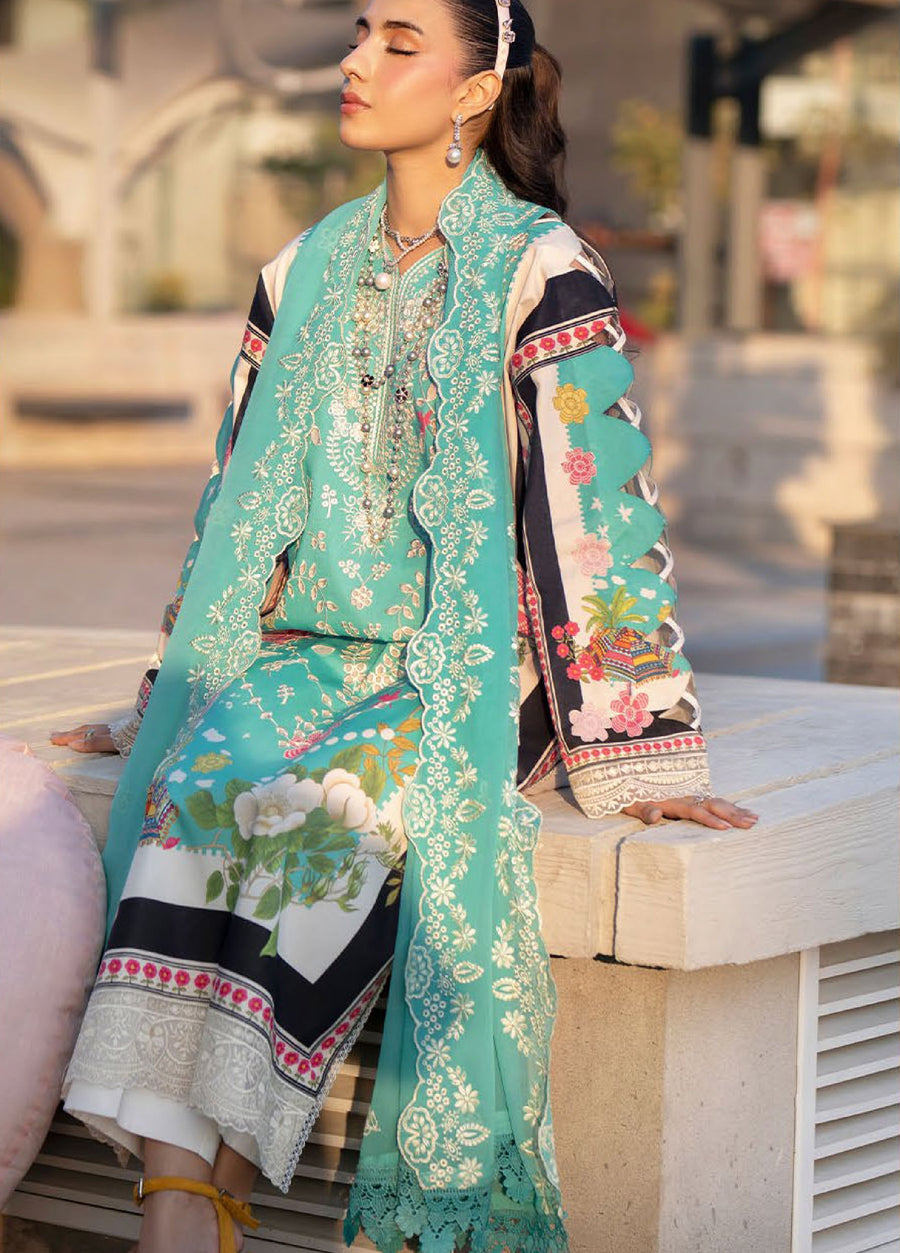 Close-up of seated woman highlighting intricate embroidery details on front and dupatta, accessorized with pearl earrings and necklace.