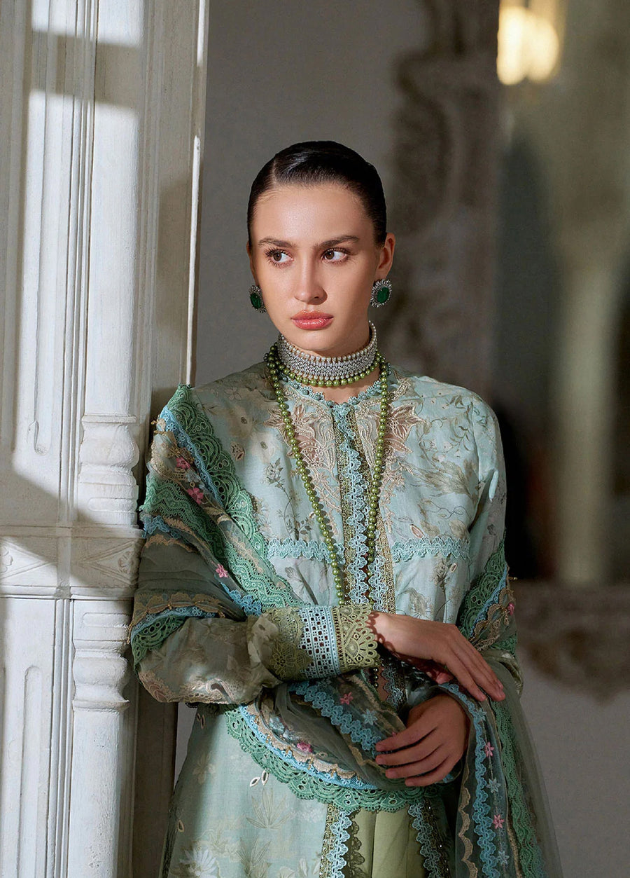 Side view of woman leaning against a wall, highlighting the embroidered front panel of the lawn shirt and sheer dupatta with floral accents