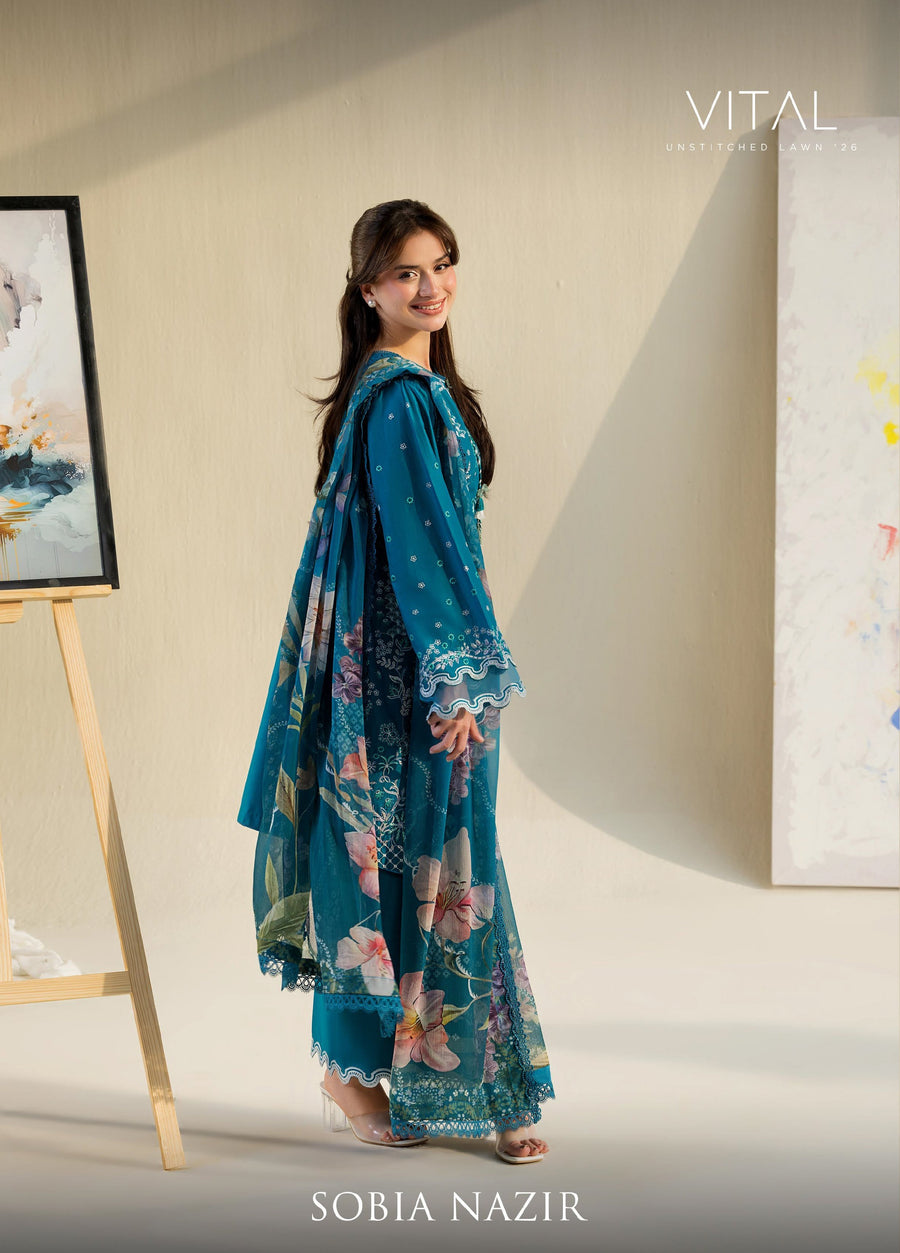 Back view of woman smiling, showing embroidered shirt and floral chiffon dupatta with scalloped lace edges