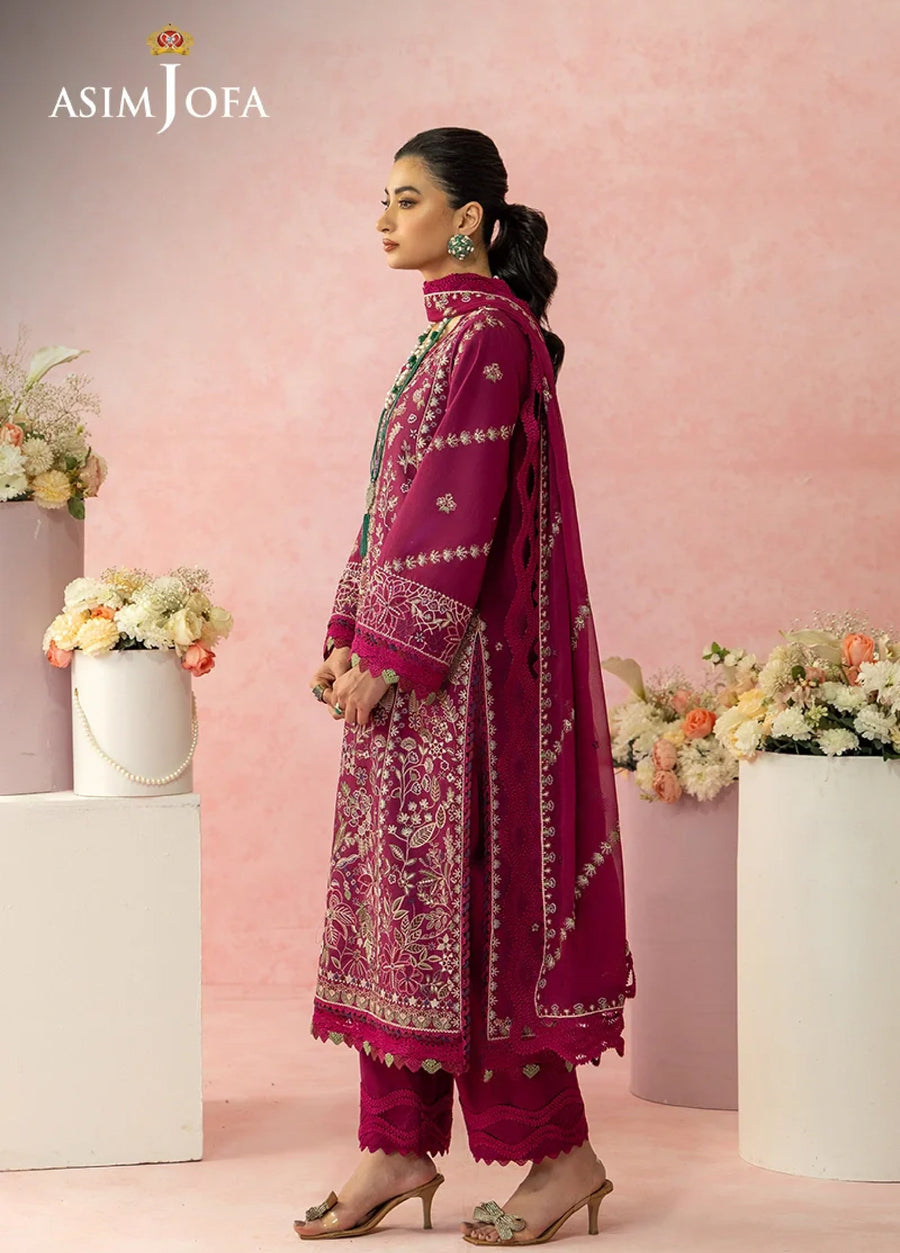 Side view of embroidered magenta lawn suit showing detailed sleeve embroidery, scalloped pant hems, and flowing dupatta with border.