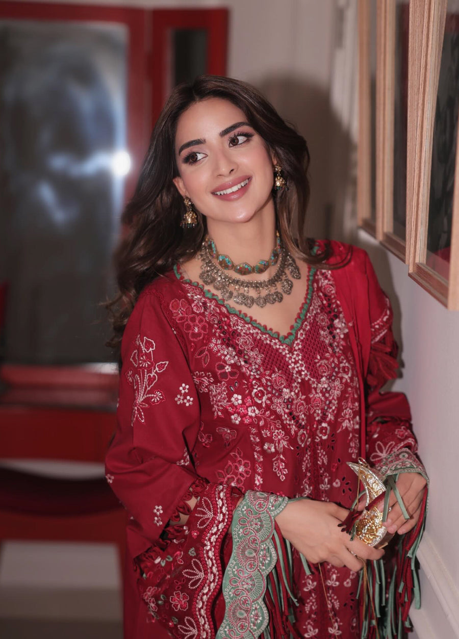 Smiling woman wearing red embroidered suit holding the matching floral-embroidered dupatta with green accents