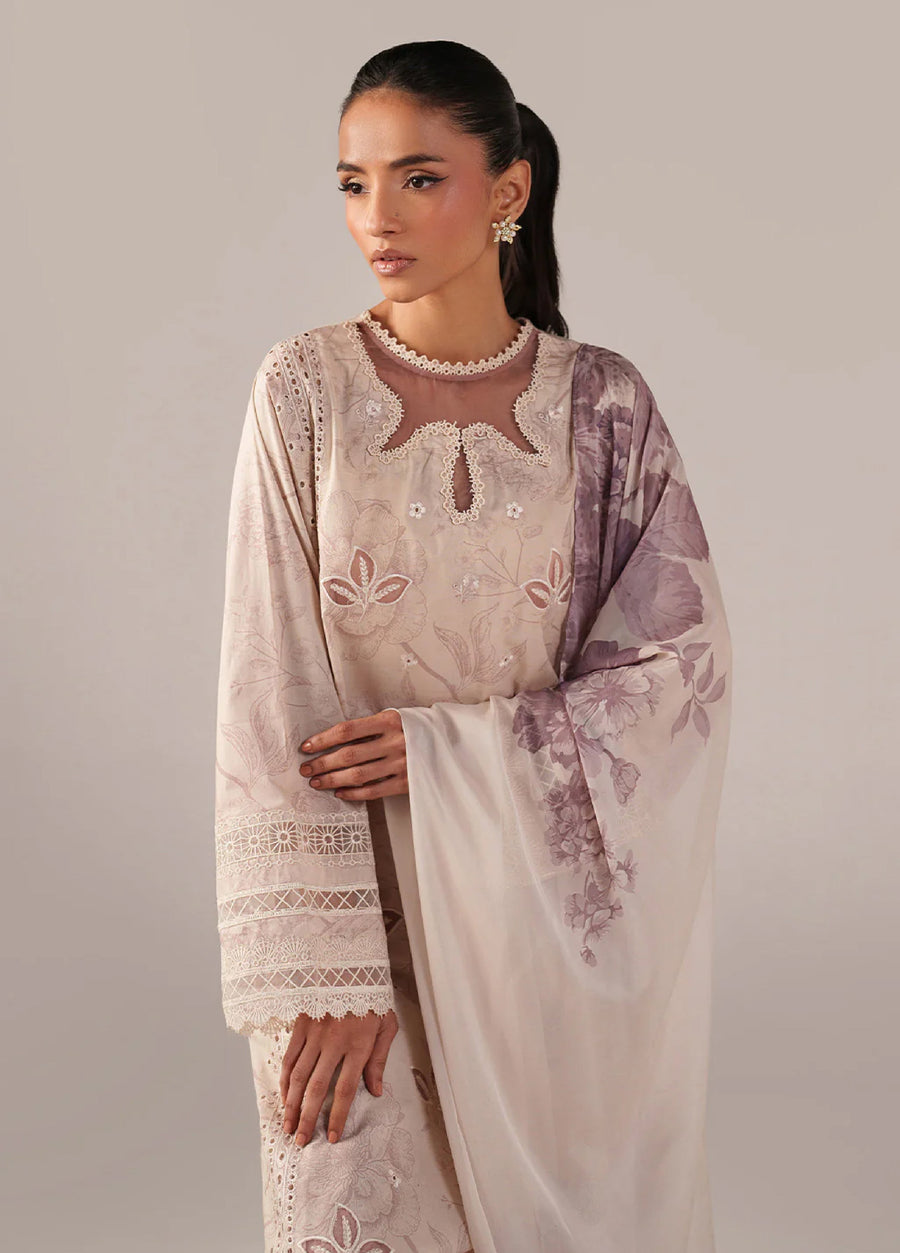 Close-up of the lower hem of the lawn suit displaying intricate floral embroidery and lace details, paired with matching straight pants and embellished sandals