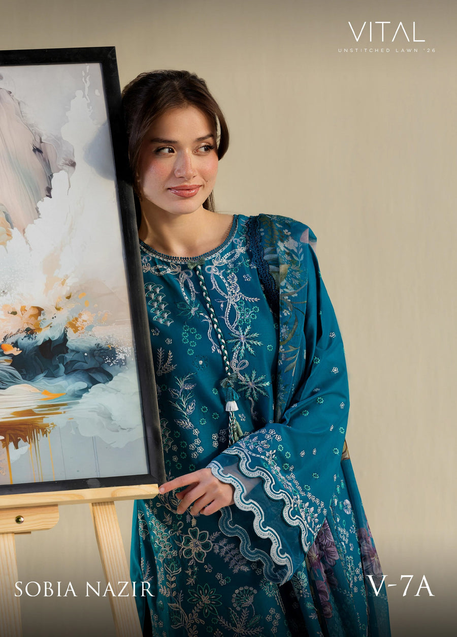 Close-up of woman smiling in teal embroidered lawn suit with detailed neckline and cuffs with scalloped lace accents