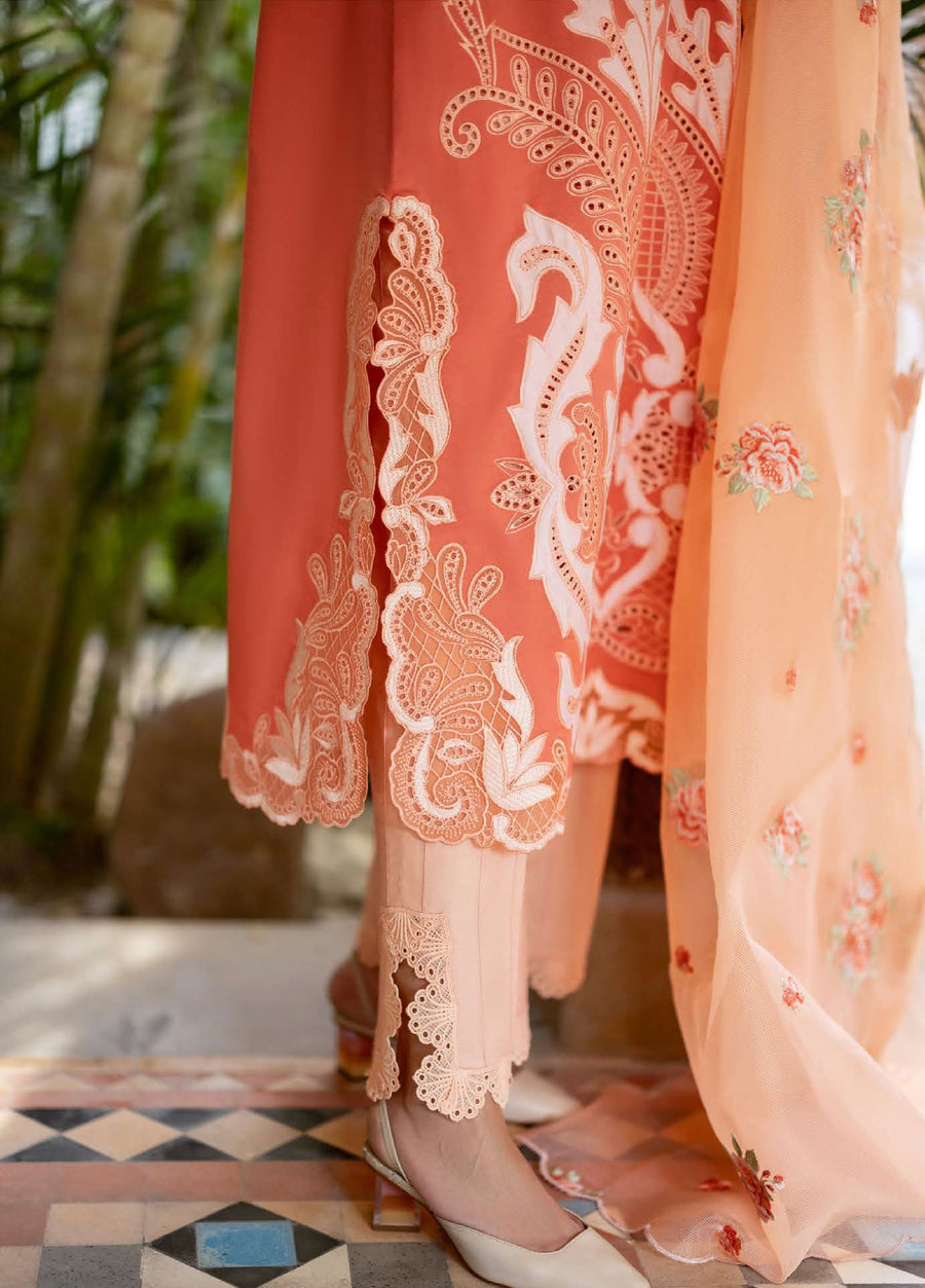 Close-up of embroidered detail on peach lawn suit sleeve and lace detailing on cream cotton trousers, paired with beige heels
