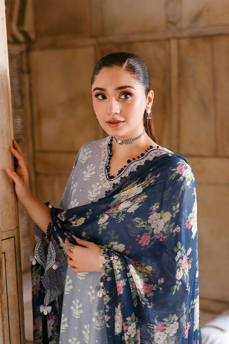 Close-up of woman in sky blue embroidered lawn suit with navy floral chiffon dupatta draped over shoulder