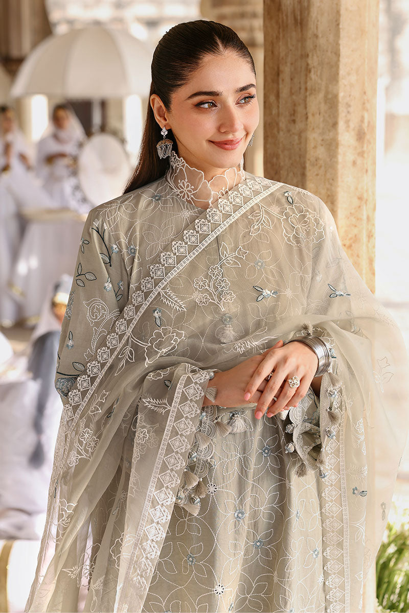 Close-up of woman in beige embroidered lawn suit showing detailed floral embroidery and tassel accents on high neck collar and organza dupatta
