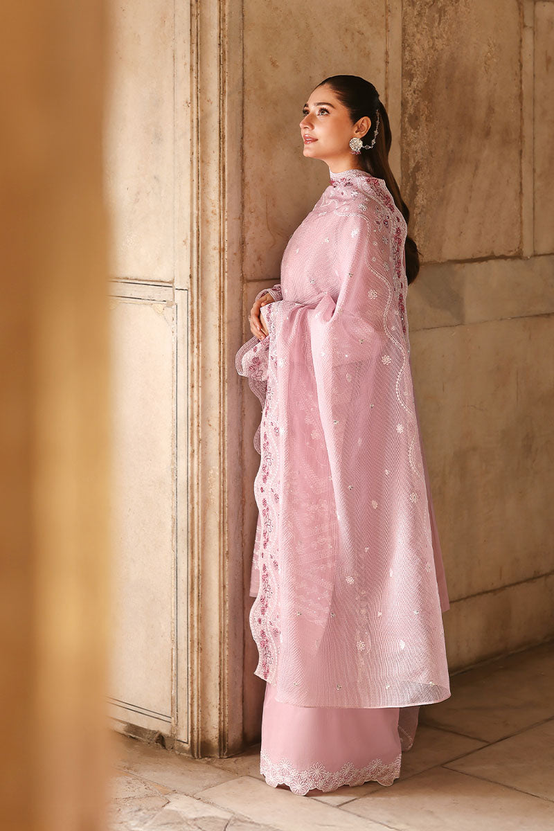 Model gazing out a window wearing the embroidered lawn suit and net dupatta draped elegantly