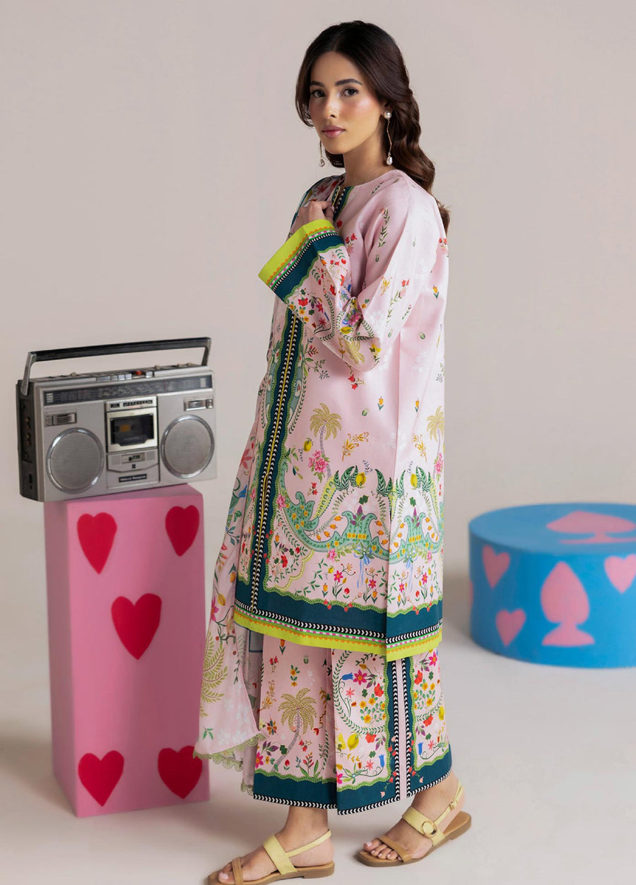 Side view of woman wearing pastel pink floral printed lawn suit showing detailed floral motifs and border designs with modest style