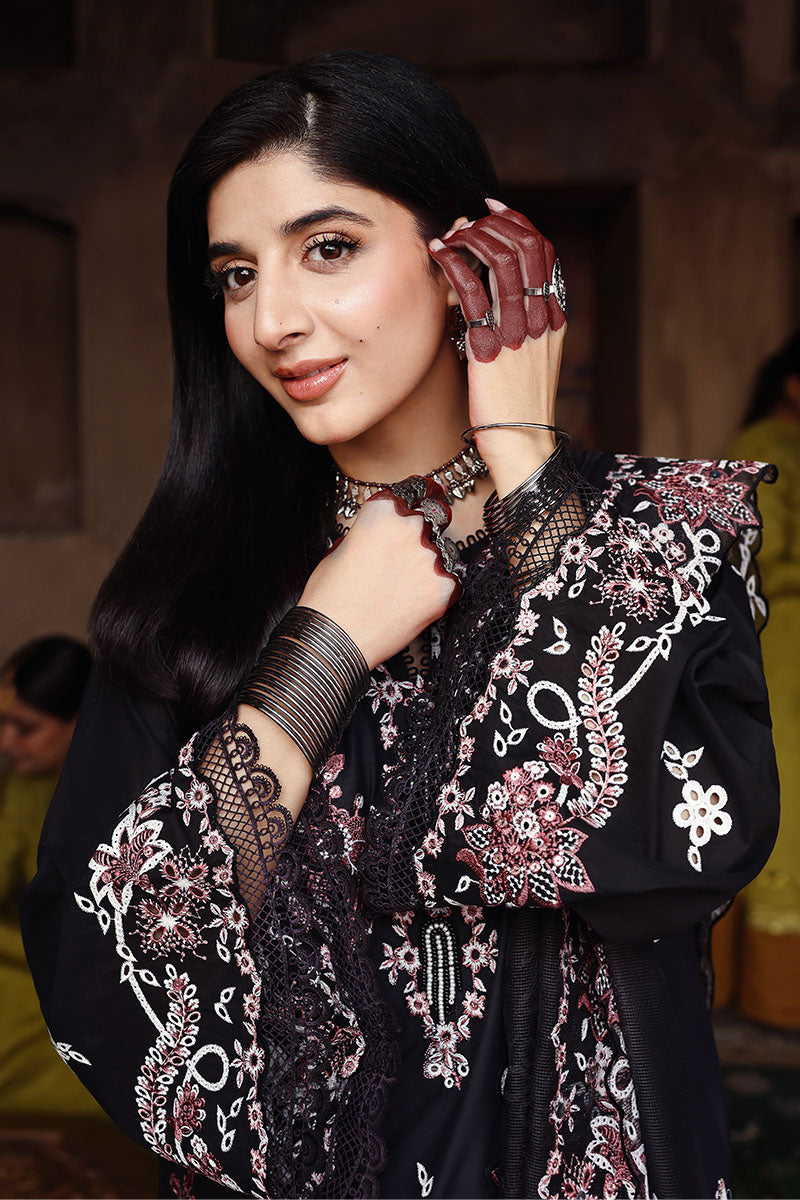 Close-up view of the woman’s embroidered sleeve and neckline showing detailed floral embroidery and lace trim, wearing silver bangles and rings.