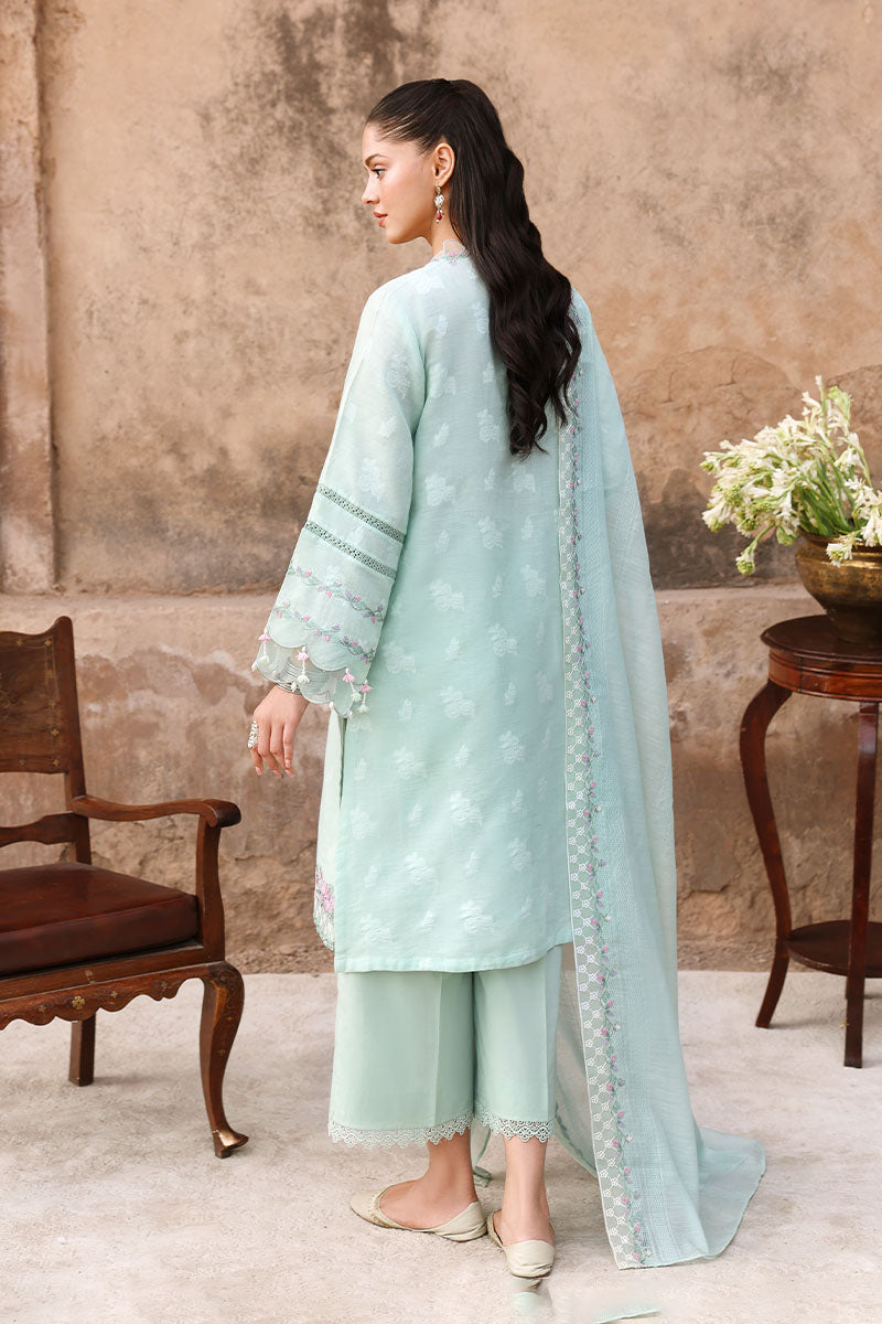 Rear view of model wearing pastel mint green embroidered three-piece suit highlighting back embroidery and flowing dupatta