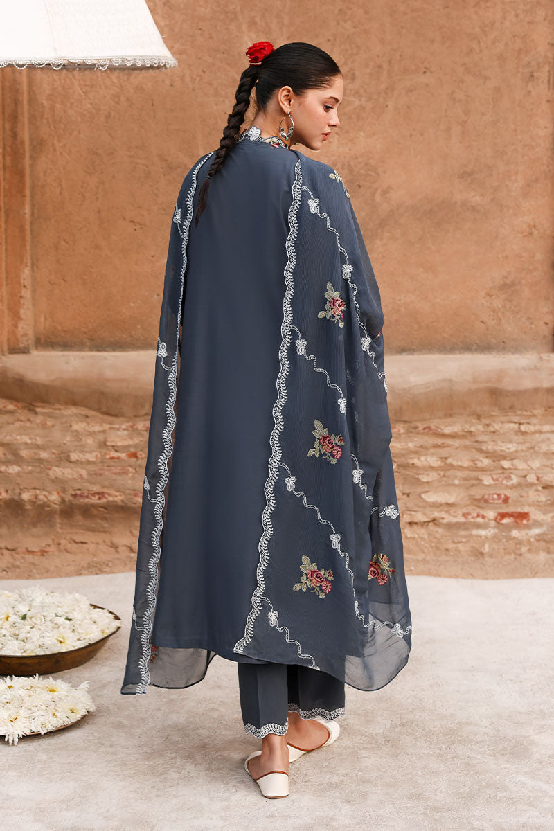 Back view of the woman highlighting the embroidered design on the kameez and sheer dupatta along with the straight pants