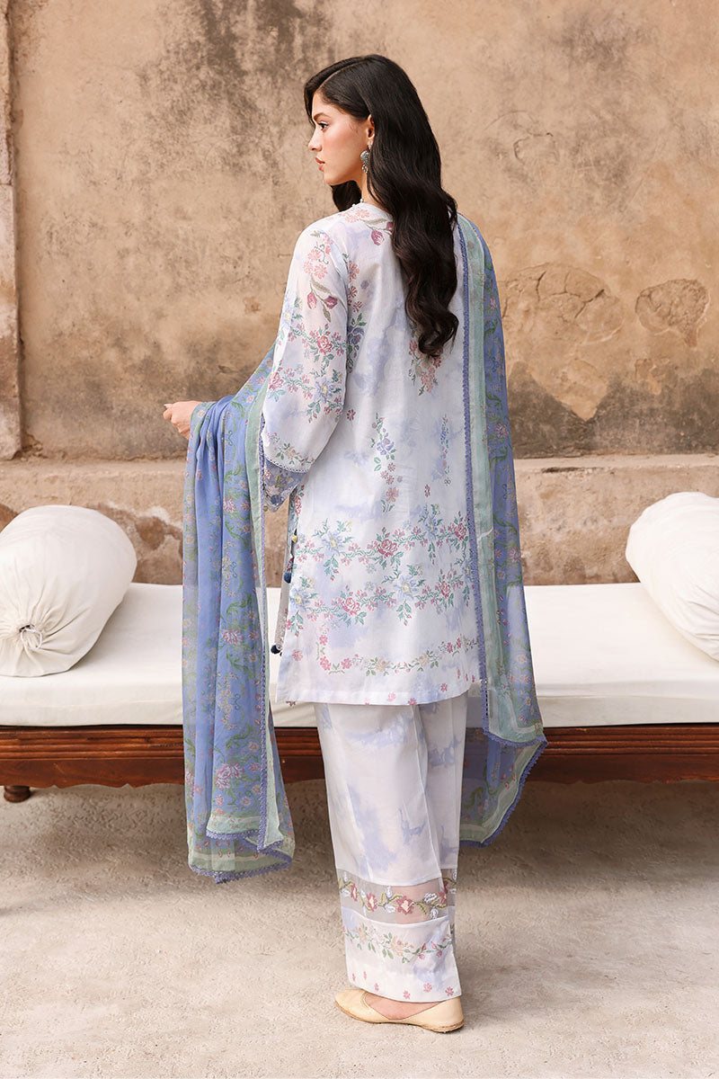 Back view of woman wearing floral print lawn suit with chiffon dupatta flowing, showing detailed print and embroidery on the back