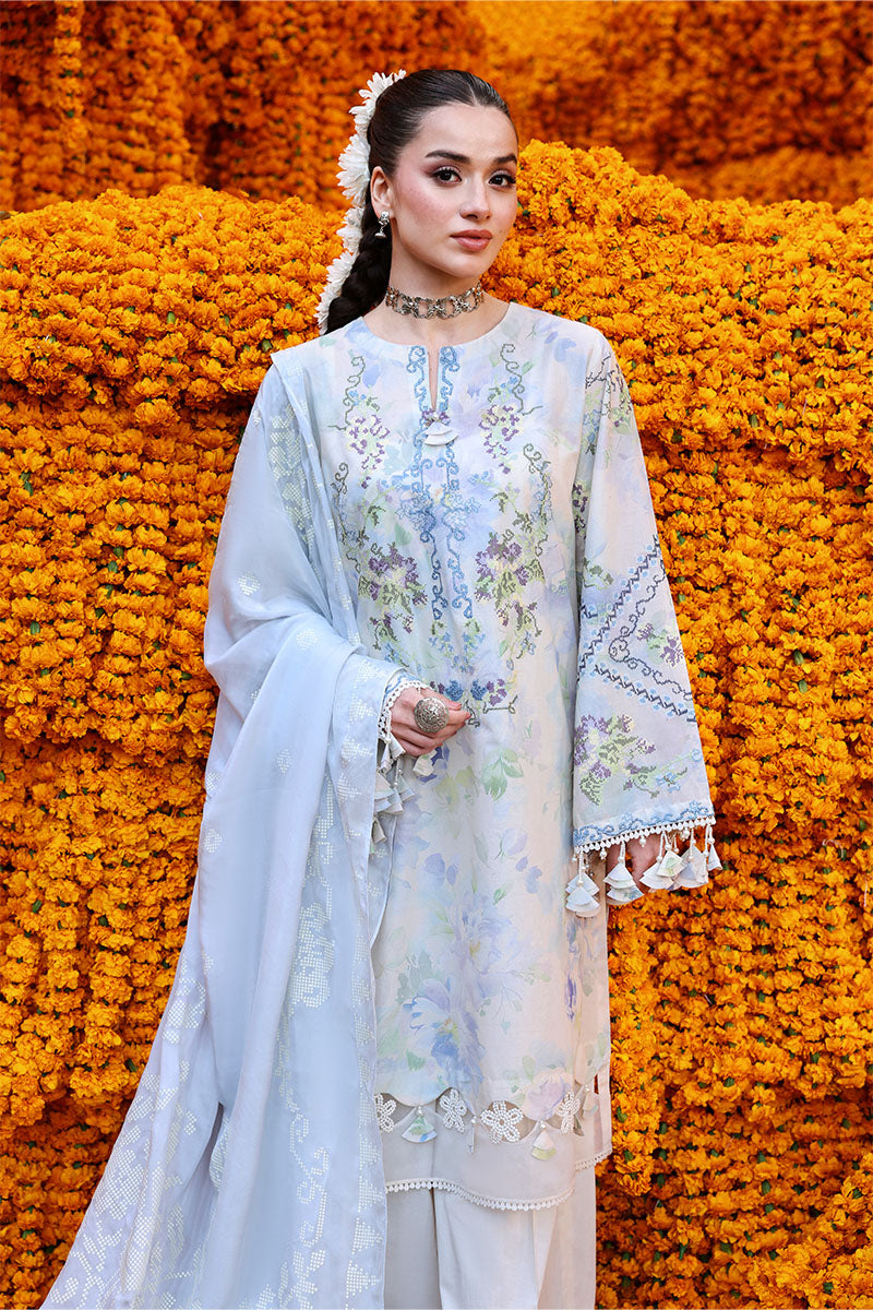 Close-up of woman modeling front of pastel floral embroidered lawn suit with delicate embellishments and tassels on sleeves