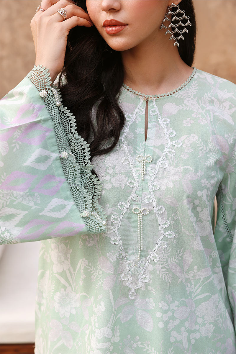 Close-up of embroidered neckline and cuff details on the sage green lawn shirt, highlighting pearl embellishments and lace trim