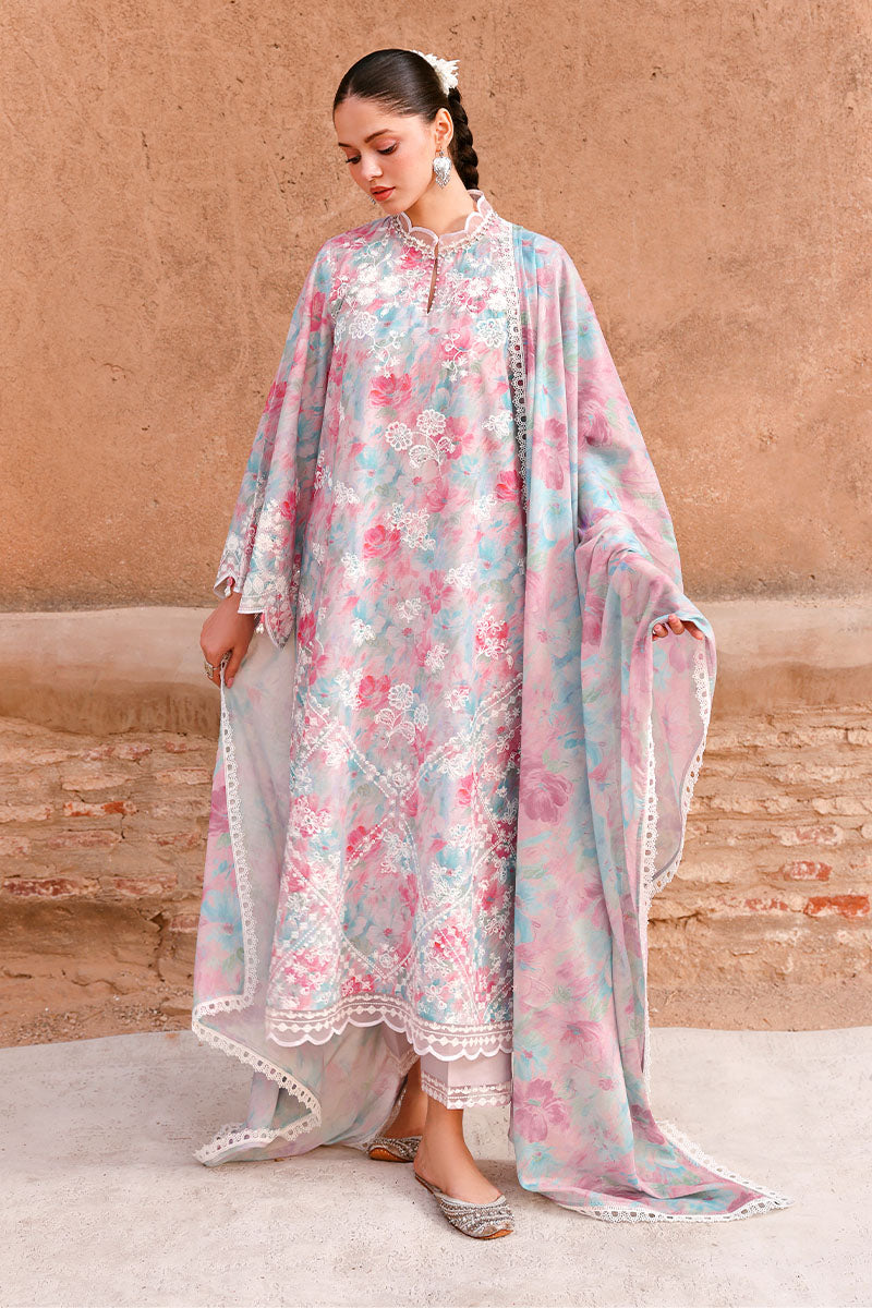 Woman wearing pastel floral embroidered lawn suit holding matching dupatta in outdoor setting