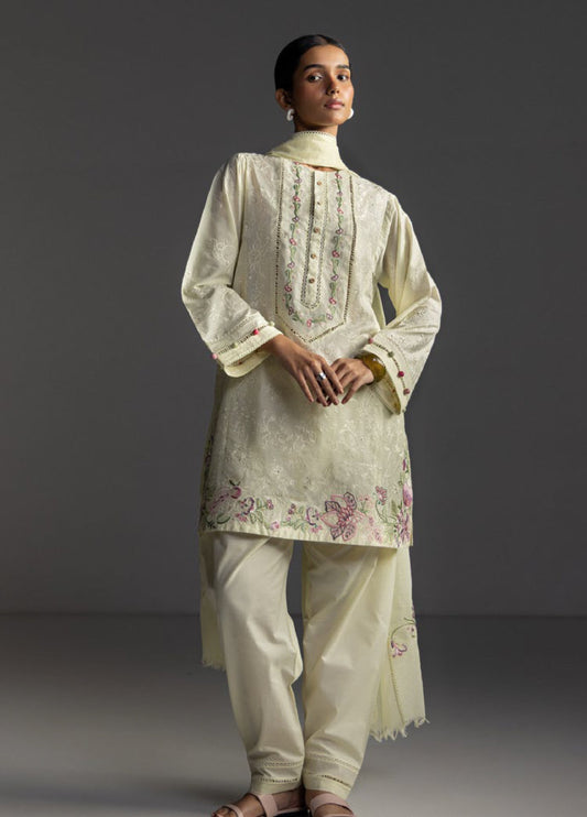 Front view of a woman wearing an elegant vanilla embroidered lawn shirt with floral and chikankari patterns paired with vanilla trousers and matching dupatta