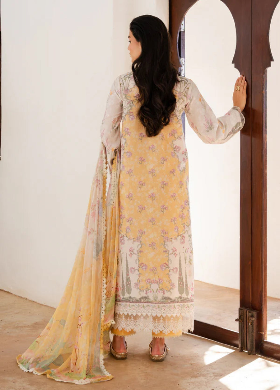 Back view of woman wearing yellow floral printed lawn kurta with dupatta draped on shoulder standing by wooden door
