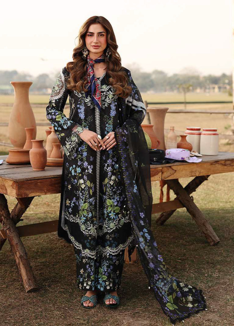 Woman modeling a black floral embroidered lawn suit standing outdoors by a rustic wooden table with pottery.
