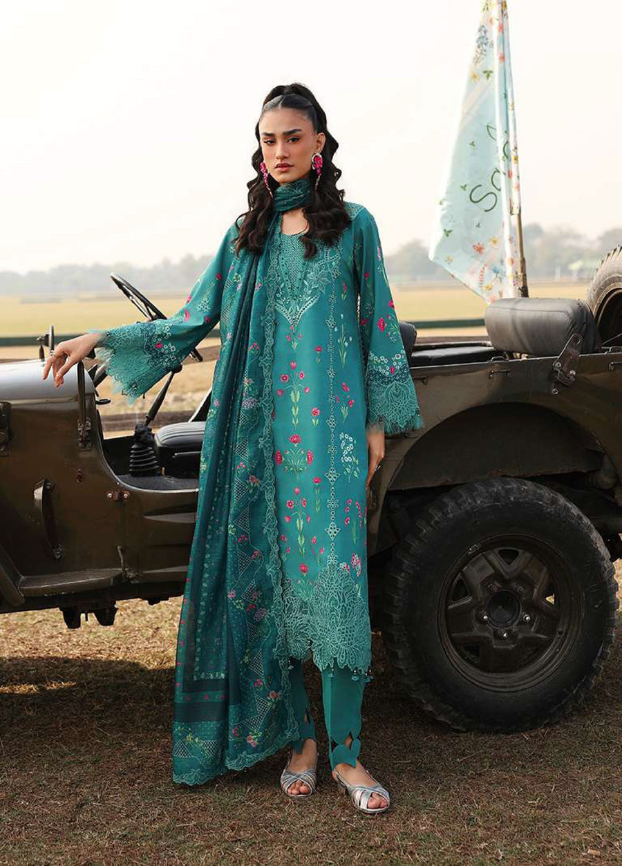 Woman wearing teal embroidered lawn suit with floral patterns standing by a vintage military jeep outdoors