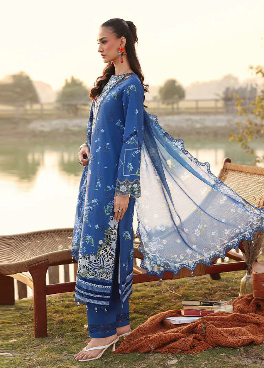 Side view of a woman in a blue embroidered lawn suit showing flowing dupatta with scalloped lace edges and detailed sleeve embroidery