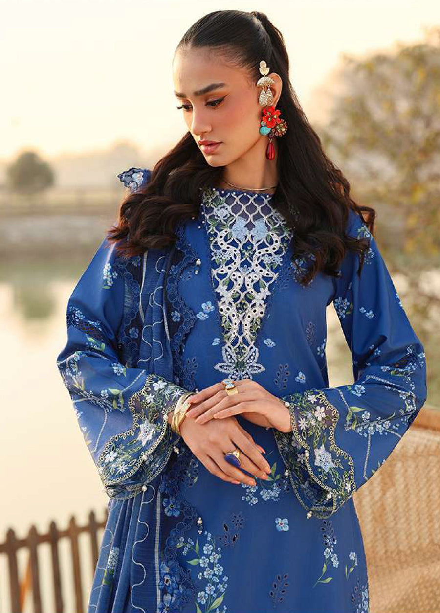 Close-up of the embroidered neckline and sleeves of the blue lawn suit worn by a woman, highlighting intricate floral embroidery and accessories