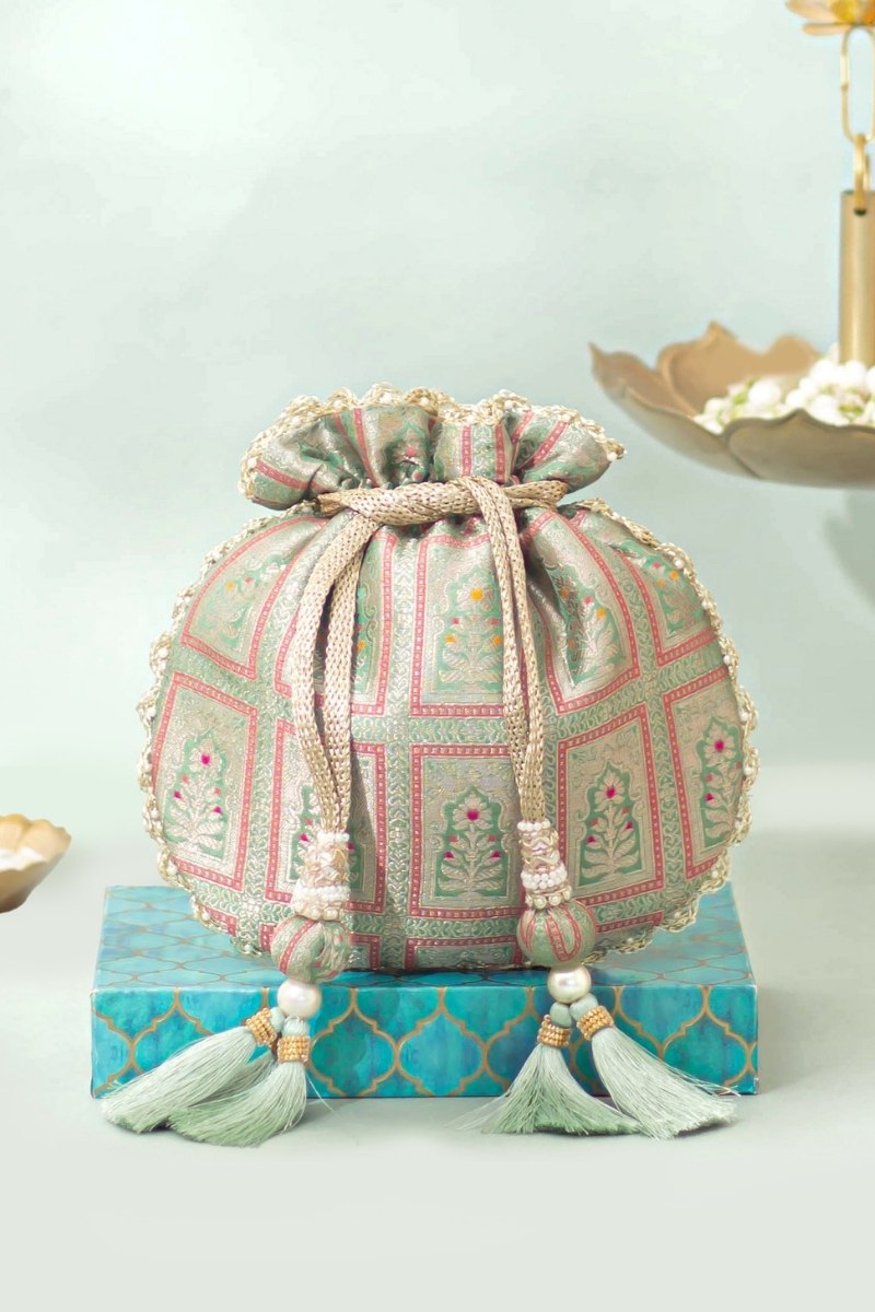 Traditional Banarasi silk potli bag in teal with intricate floral brocade print, scalloped lace edges, and decorative drawstring tassels