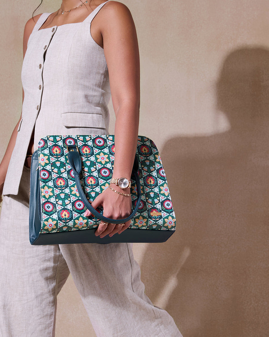 Close-up of woman holding floral patterned tote bag in hand wearing beige outfit and gold accessories