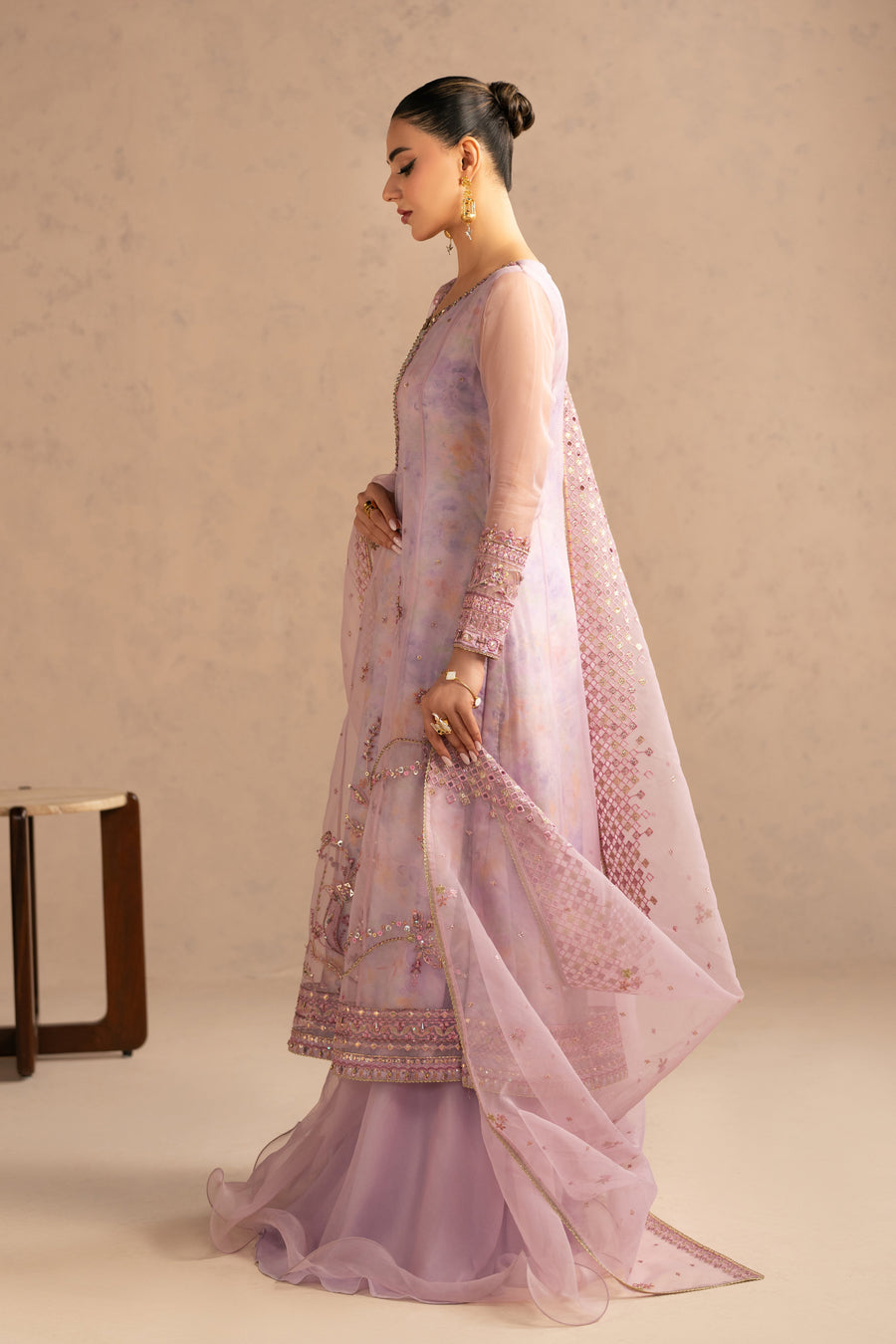 Side profile of woman showcasing sheer organza sleeves and embroidery details of mauve frock style suit with dupatta