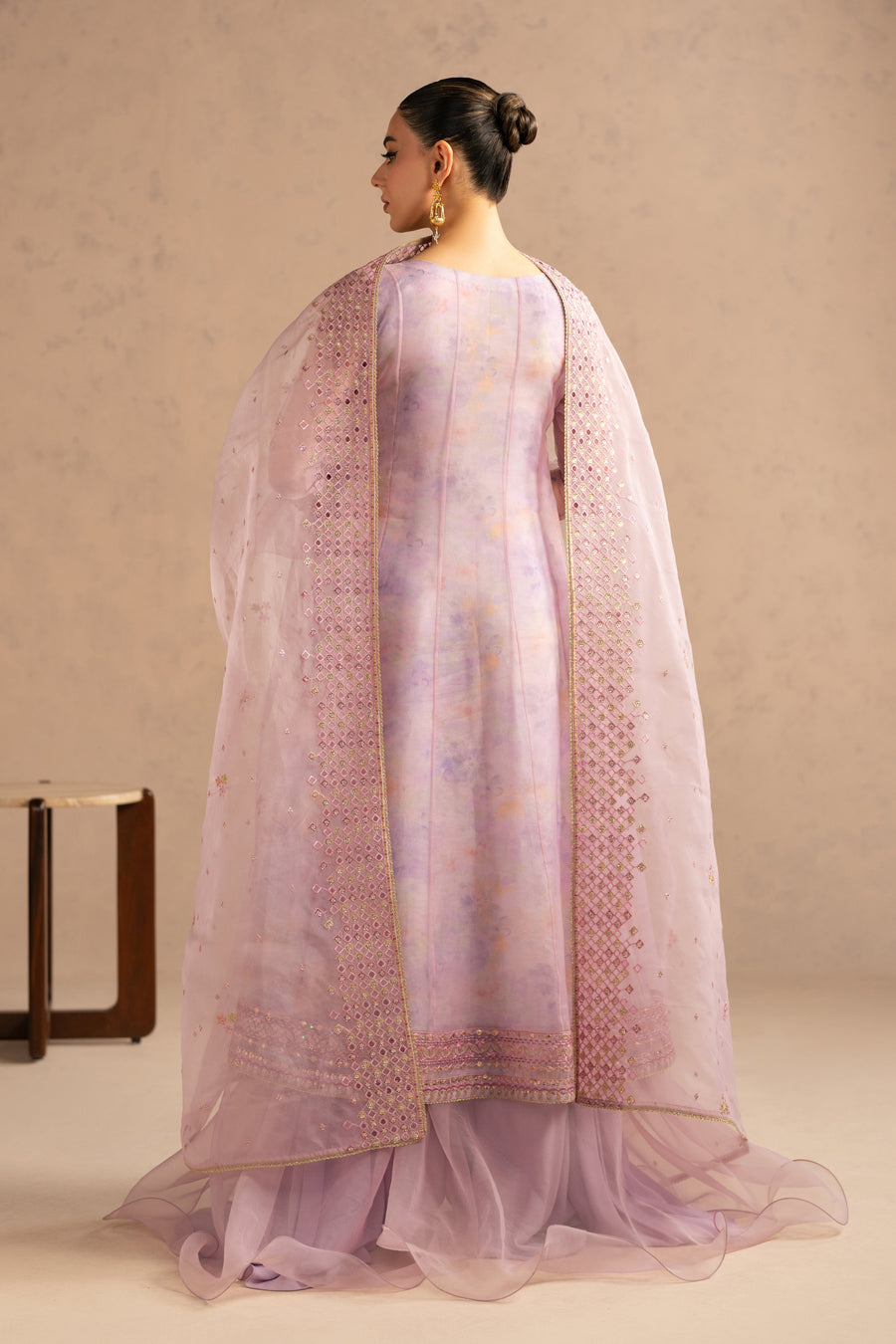 Back view of woman in mauve organza suit highlighting smooth back design and detailed embroidery on sheer dupatta