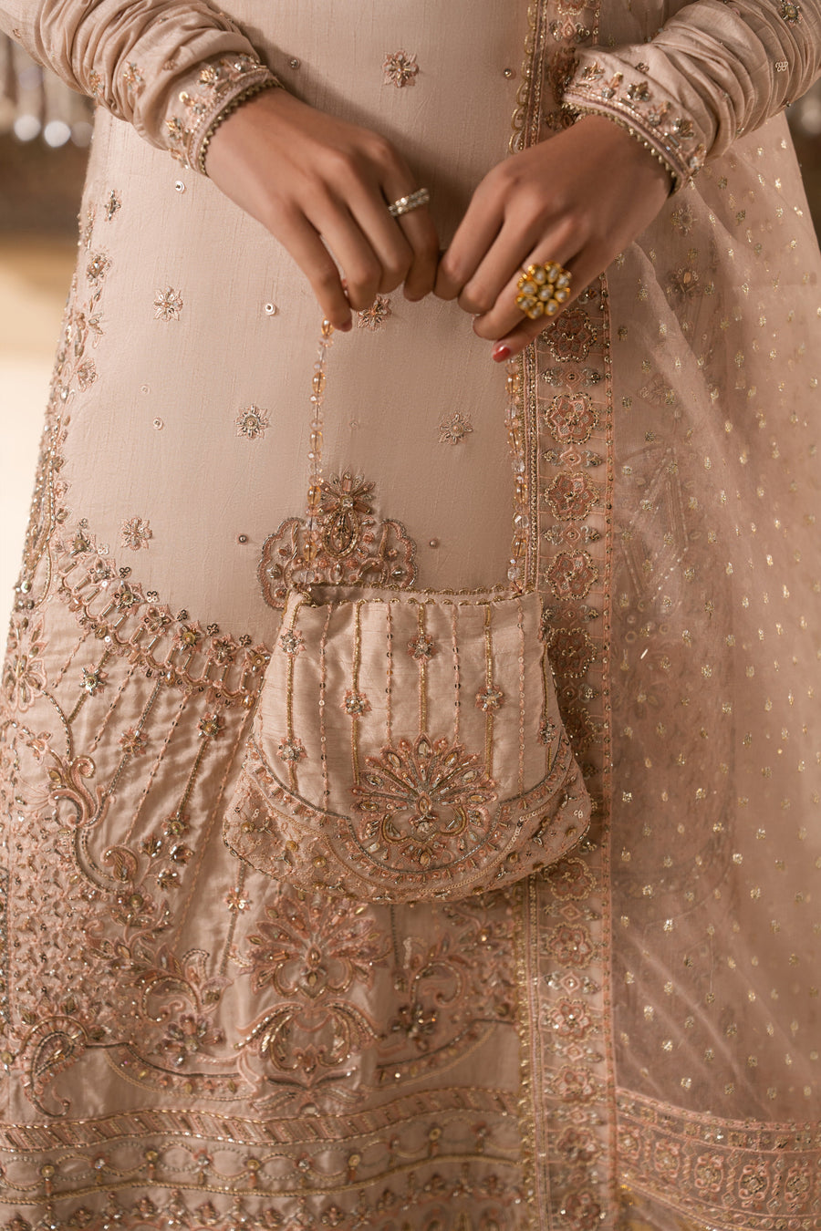 Close-up of upper body with heavily embroidered neckline and delicate sequin work on sleeves of pale peach sharara set