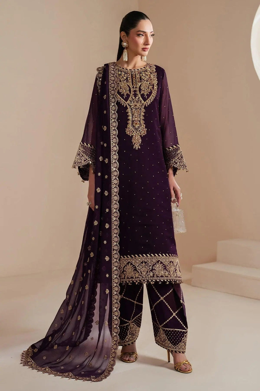 Front view of woman wearing deep purple embroidered chiffon three-piece suit with gold thread embroidery and matching dupatta