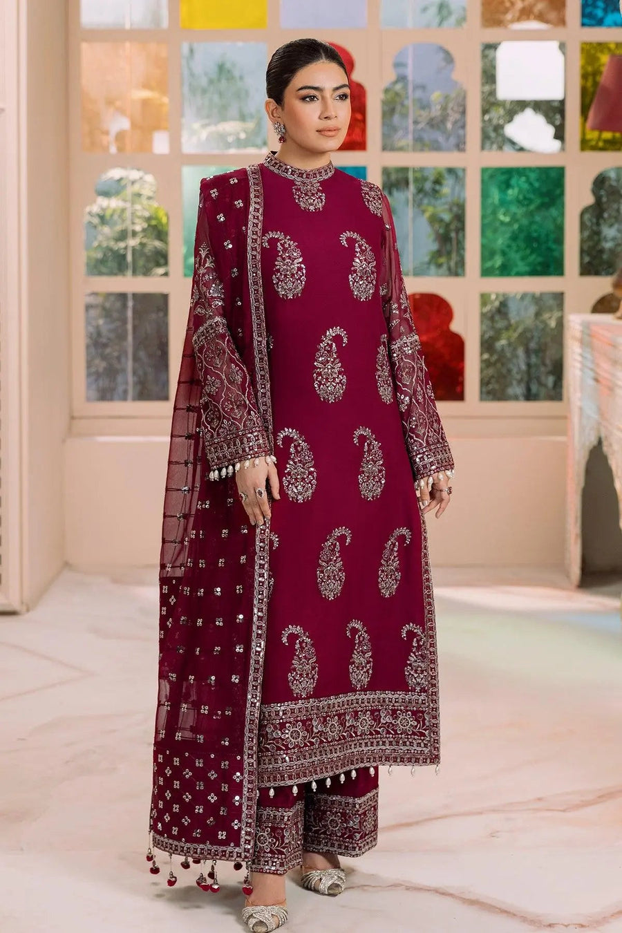 Close-up of embroidered sheer sleeves and pearl tassel details on magenta traditional outfit
