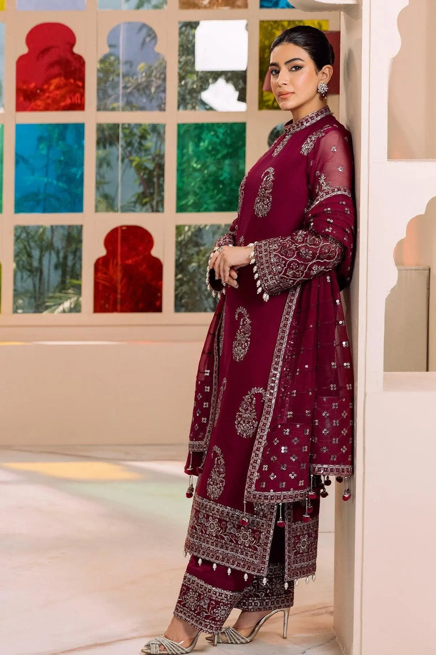 Detailed close-up of embroidery pattern on sleeves and border of magenta ethnic wear