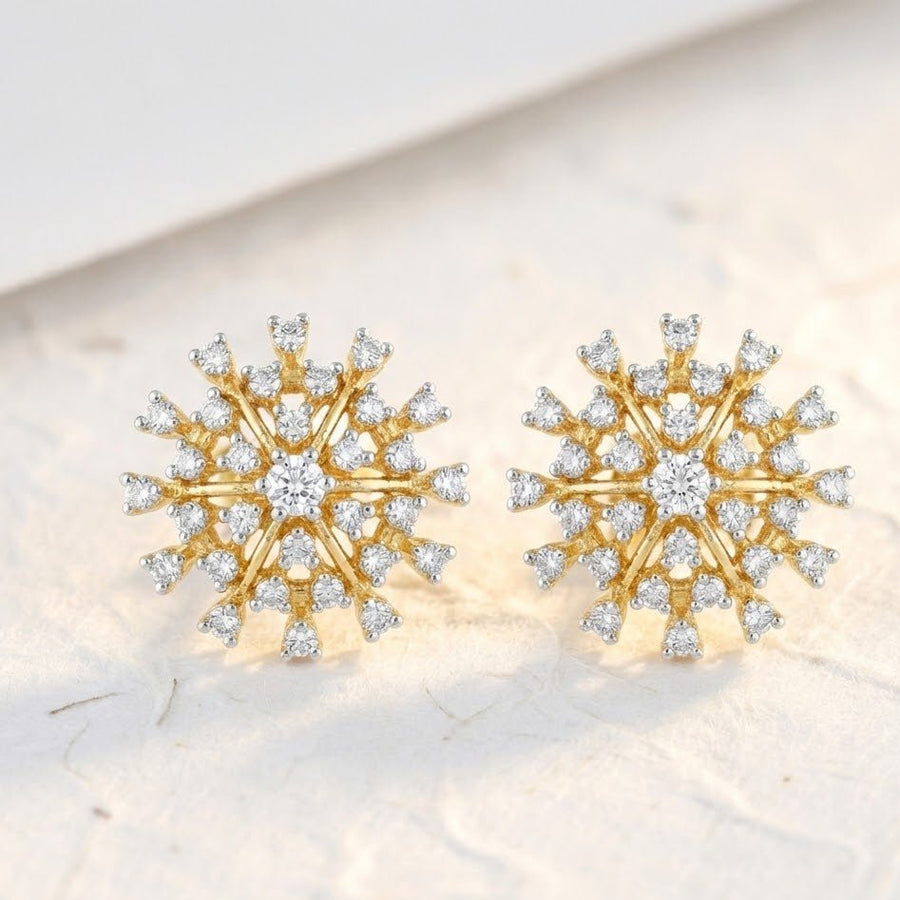 Pair of starburst crystal earrings displayed on textured cream surface with soft natural lighting