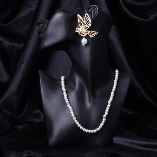 Black mannequin bust showcasing gold bird pearl earrings paired with white pearl necklace on a black silk background