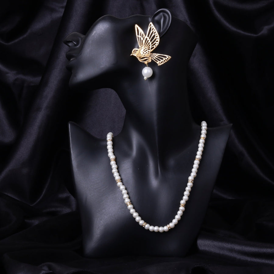 Black mannequin bust showcasing gold bird pearl earrings paired with white pearl necklace on a black silk background