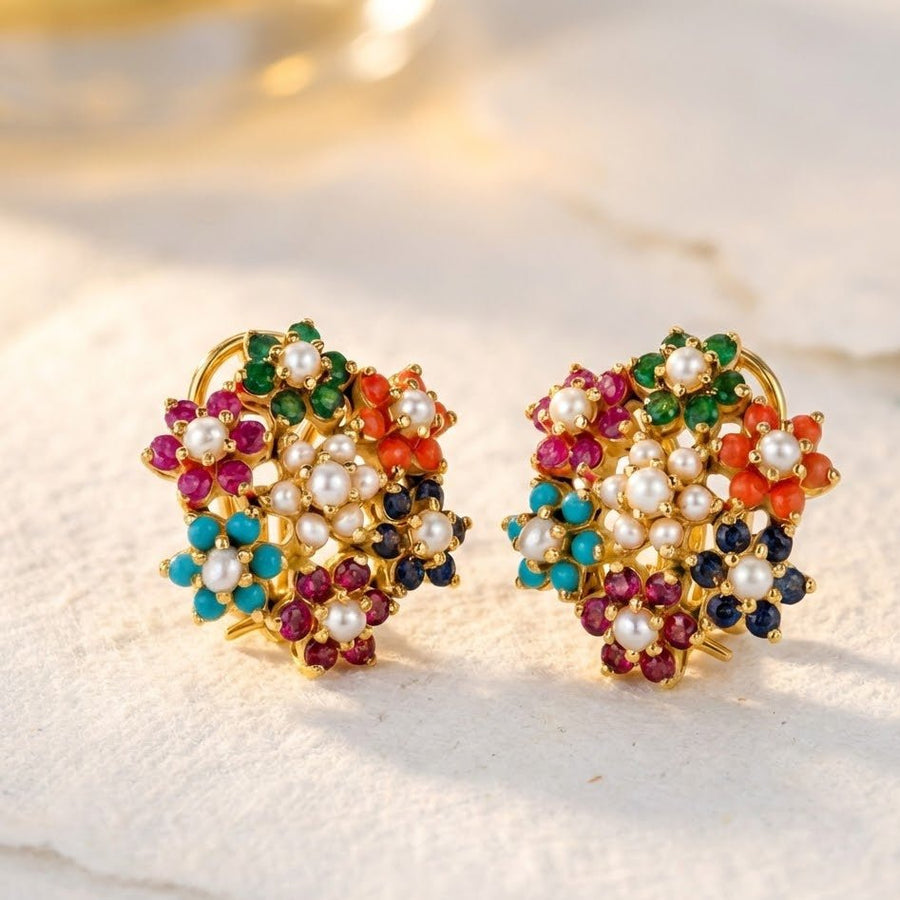 Close-up of multicolor floral cluster earrings on a light stone surface with soft lighting