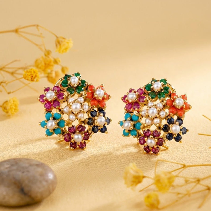 Multicolor floral cluster earrings displayed on yellow fabric with decorative dried flowers and stone