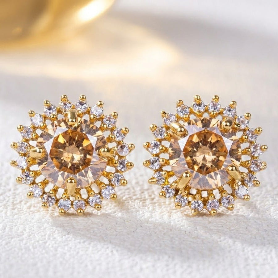 Champagne gemstone halo stud earrings arranged on soft beige fabric with dried flowers