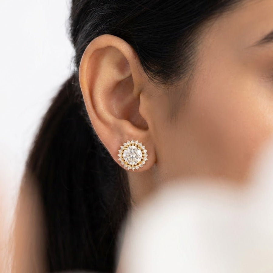 Woman wearing clear gemstone halo stud earrings showing ear profile and elegant look