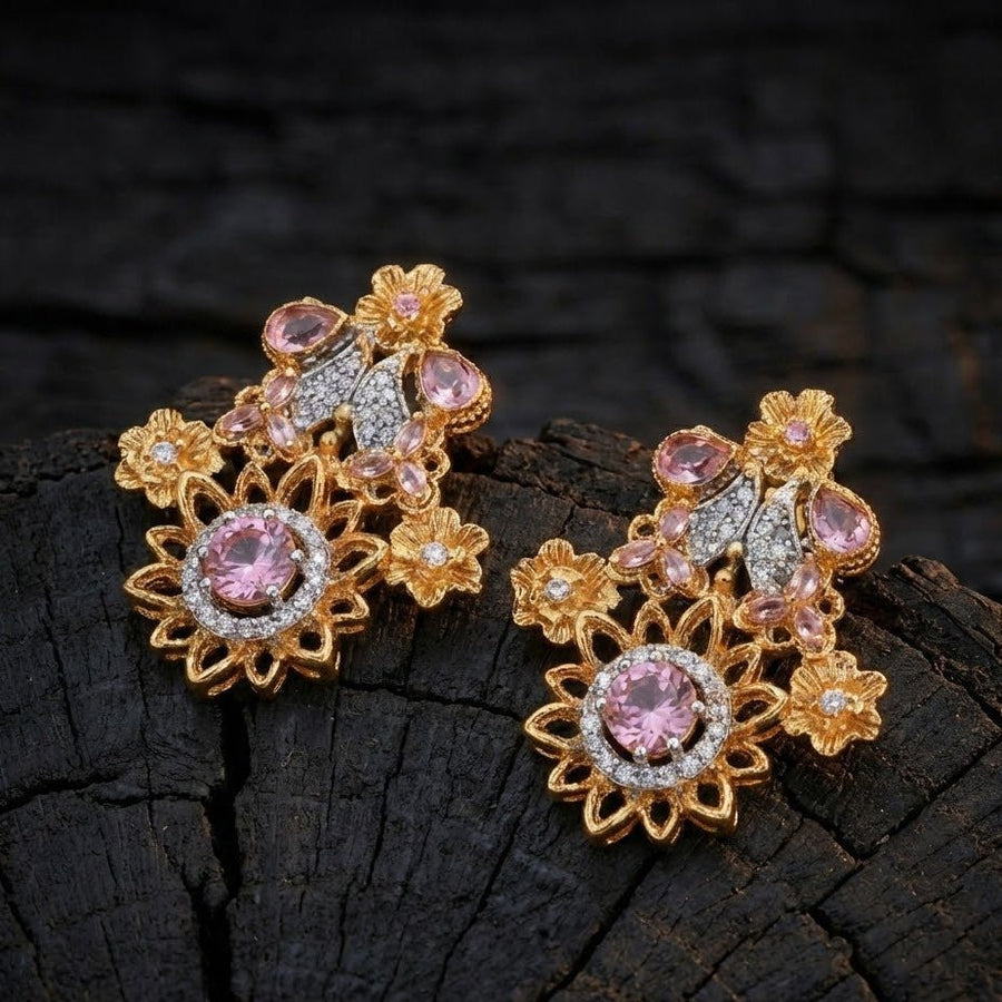 Woman smiling wearing pink floral gemstone earrings with traditional beige embroidered dress indoors