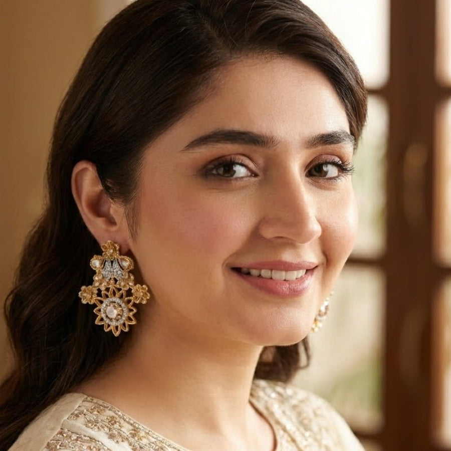 Close portrait of woman wearing champagne beige floral gemstone earrings paired with embellished cream outfit