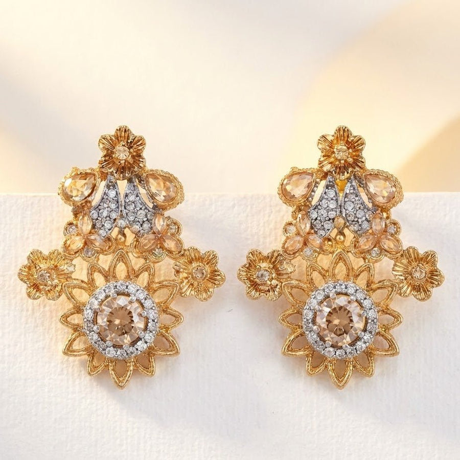 Champagne beige floral gemstone earrings with clear stones arranged on cream fabric softly lit