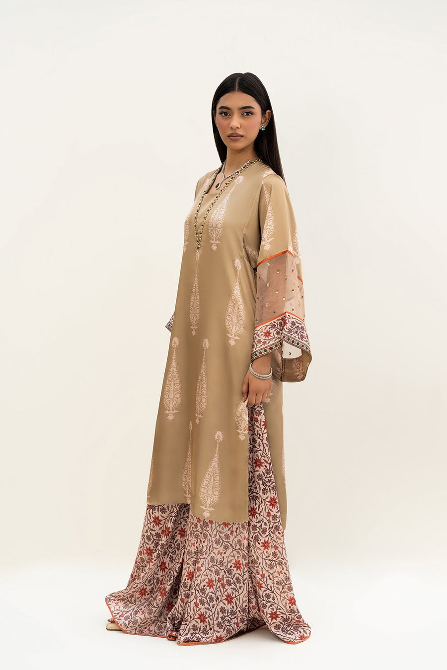 Side angle of woman showing the kurta’s loose fit, side slit, and floral printed palazzo pants.
