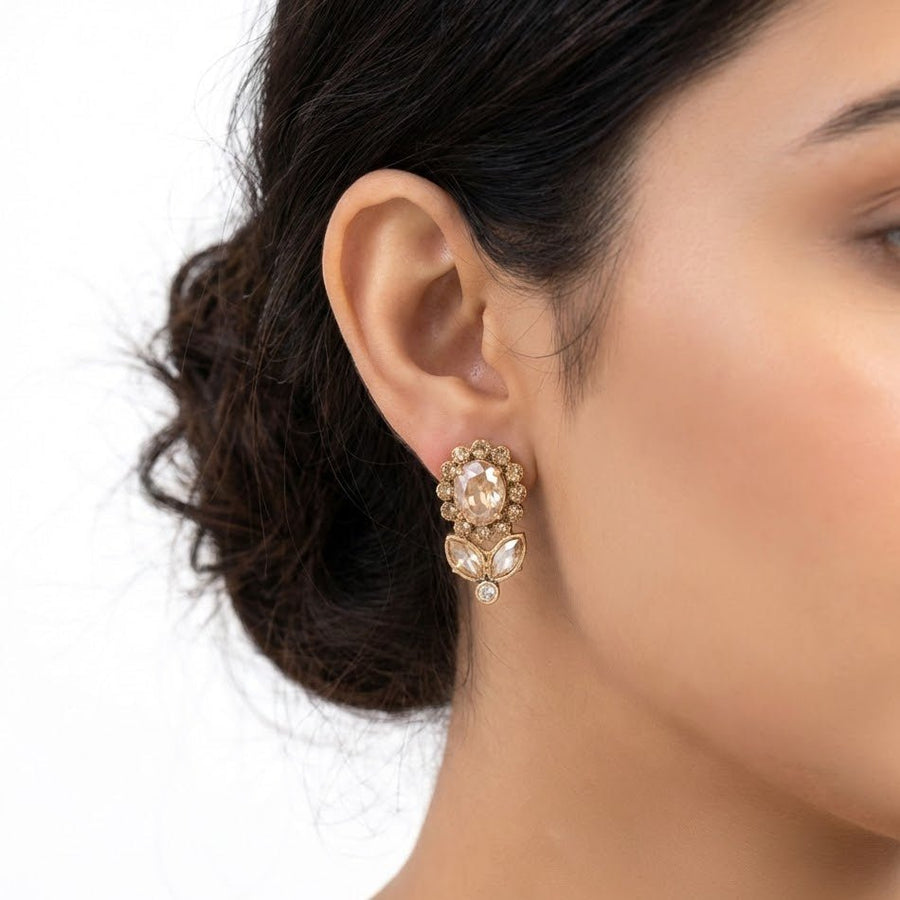 Close-up of woman wearing gold-tone floral crystal earrings highlighting their elegant fit and design