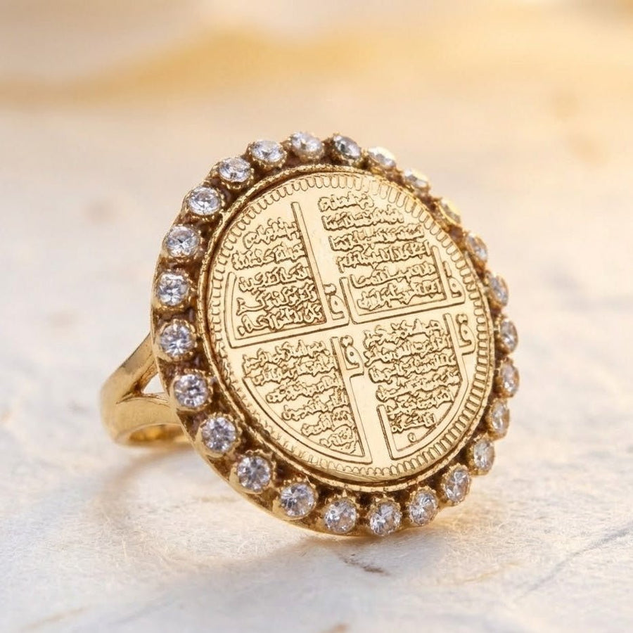 Angle view of Chaar Qul ring showing gold coin engraving and sparkling stone border on textured surface